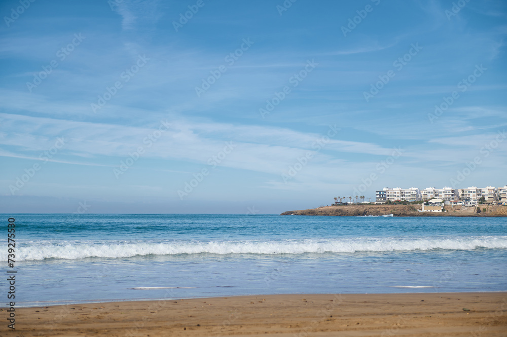 Nature background with seascape. Atlantic ocean, Waves pounding on the sandy beach against the background of white city