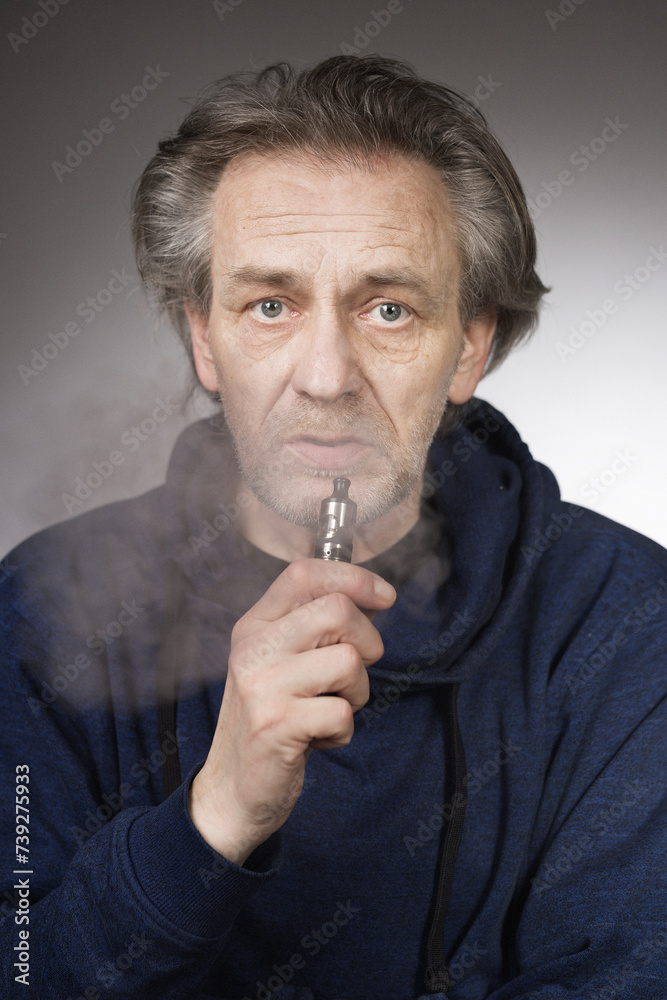 Older man with wrinkles on face skin smoking electronic cigarette Older man with wrinkles on face skin smoking electronic cigarette