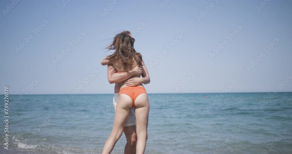 Couple on a sand beach hugging and spinning together. Enjoying summer at sea concept. Recorded at 50fps Couple on a sand beach hugging and spinning together. Enjoying summer at sea concept. Recorded at 50fps