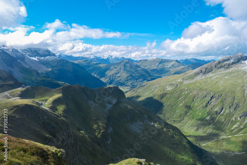 Panoramic view of alpine cottage Hagener Huette surrounded by majestic mountain peaks in High Tauern National Park  Carinthia  Austria. Idyllic hiking trail along high altitude alpine meadow. Tourism