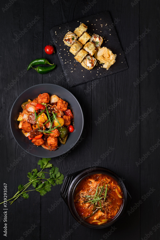 korean food. ramen soup, rolls, tofu. on a black background