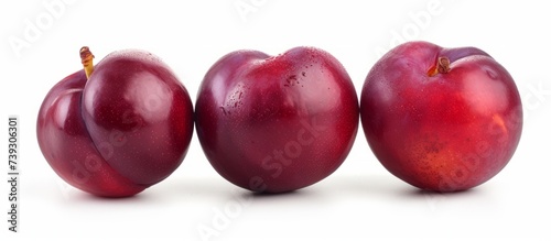 Fresh three plums with natural water droplets, close-up shot of juicy ripe fruits