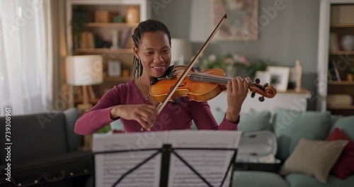 African American woman playing violin at home