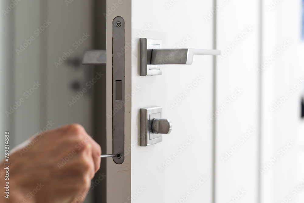 A locksmith repair the door lock in the room or handyman install the new door lock in the room