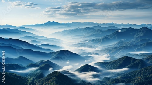 A rolling mountain range in the early morning mist, the peaks emerging and disappearing as the fog s