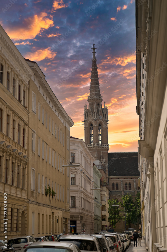 the spire of stephansdom seen from a side street at sunset