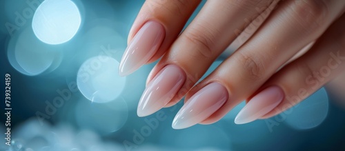 Elegant woman's hand with stylish manicure on blue background
