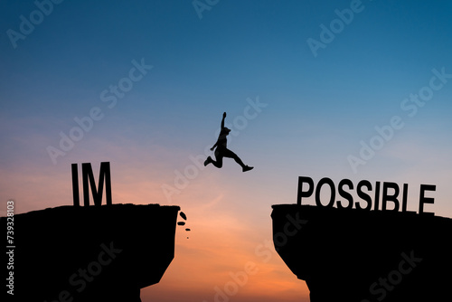 Mindset concept, Silhouette man jumping over impossible and possible wording on cliff with cloud sky and sunlight. photo
