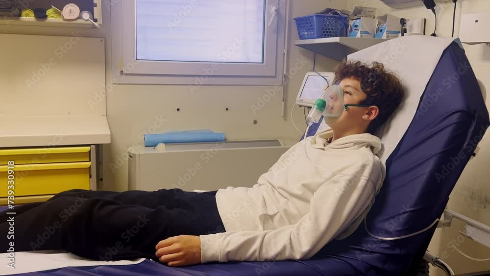 Sick teenager with an inhaler at hospital. An unhealthy child makes inhalations at hospital. Teenager to breath wears an oxygen mask to ease the course of the disease