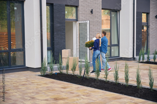 Back view photo of man and woman going towards house