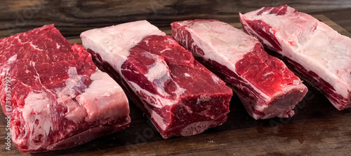 Beef Ribs Raw Meat stripes sliced on wooden board. Homemade cooking beef ribs for restaurant, menu, advert or package, close up, selective focus