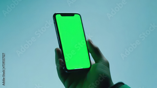 A phone with a green screen lies in the hand on a light background free space 