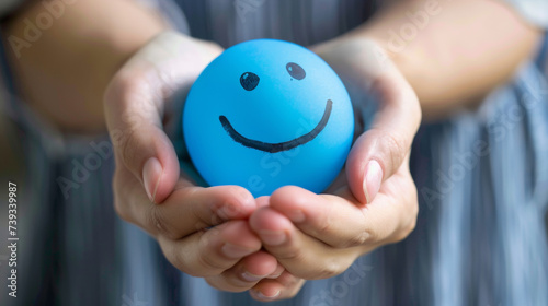 Hands holding blue happy smile face. mental health positive thinking and growth mindset, mental health care recovery to happiness emotion