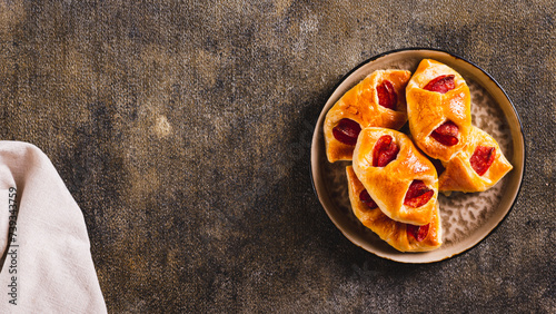 Pepperoni buns with cheese and sausage on a plate on the table top view web banner