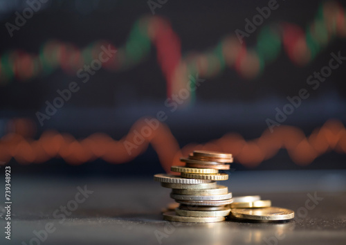 Coins currency from several different countries with stock graph background. spot focus.