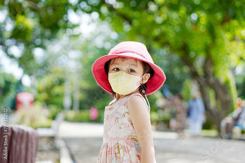 Little asian girl wearing a protective mask as protection during the Covid 19 virus outbreak. Soft focus. Copy space.