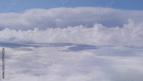 Flying in a Plane and Soft Clouds Passing by in the Blue Dreamy Sky photo