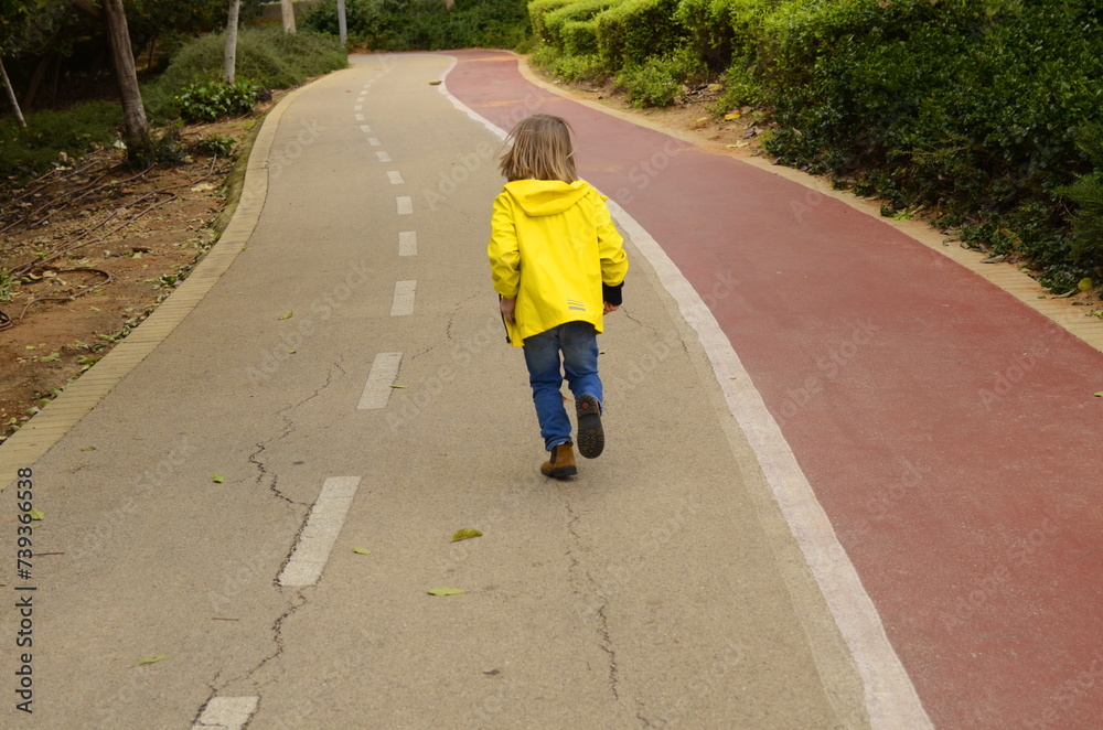 A child runs along the road. Empty asphalt road. boy running boy is walking in the park. Portrait of a cute child. A child runs along the road. Empty asphalt road. boy running boy is walking in the park. Portrait of a cute child.