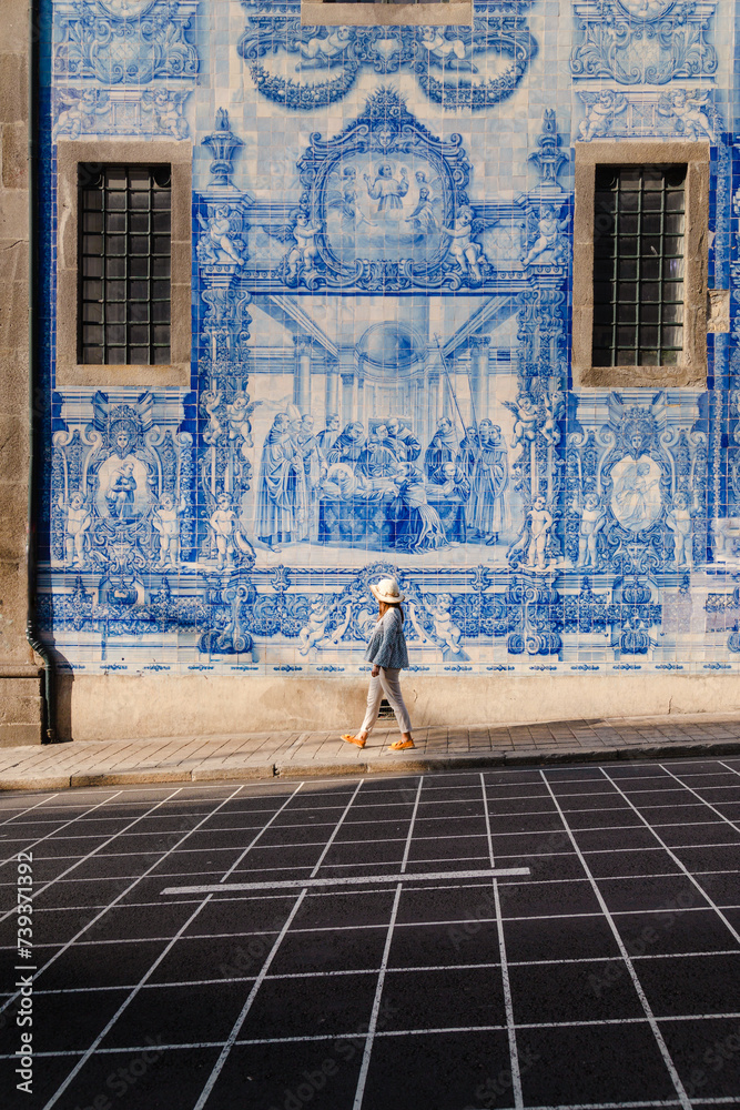 Tourist walking, blue tiles on walls, Porto, Portugal