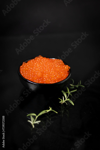 Fresh red caviar. on a black background.