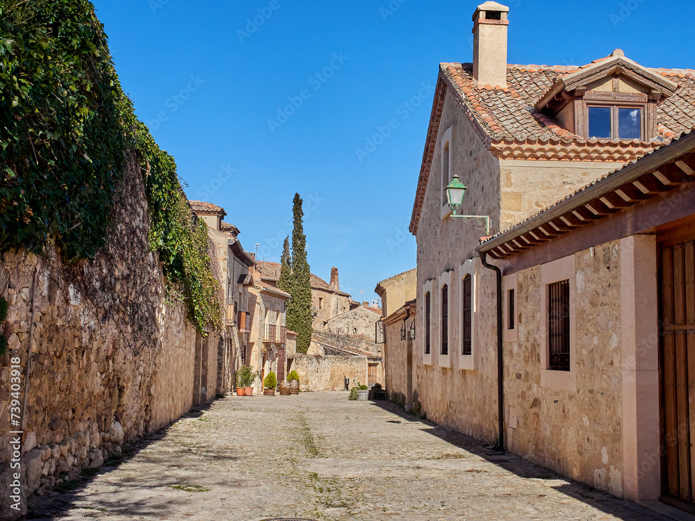 Cobblestone street with stone houses in Pedraza, a medieval walled village in the province of Segovia. Castilla y León, Spain, Europe