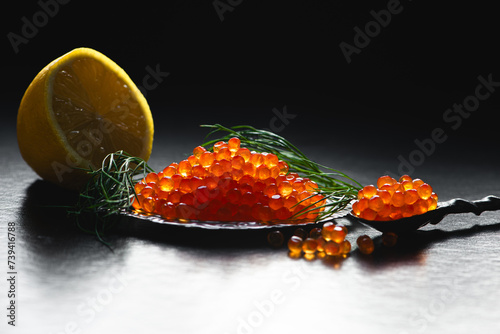 Caviar. Trout Eggs in spoon on black background.