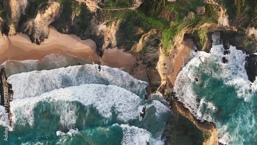 Top-down view of the cliffs and rocks washed by ocean waves. Praia dos Alteirinhos in Zambujeira do Mar, Portugal  photo