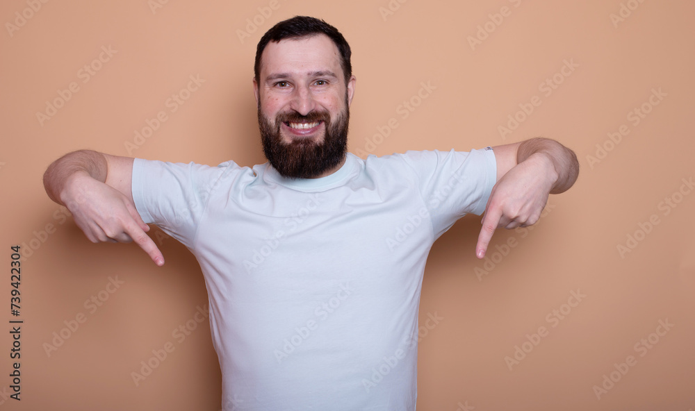 A man with a beard is smiling and pointing to the left. Concept of humor and playfulness A man with a beard is smiling and pointing to the left. Concept of humor and playfulness