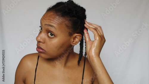Black woman untwisting her natural 4c hair on a white background photo