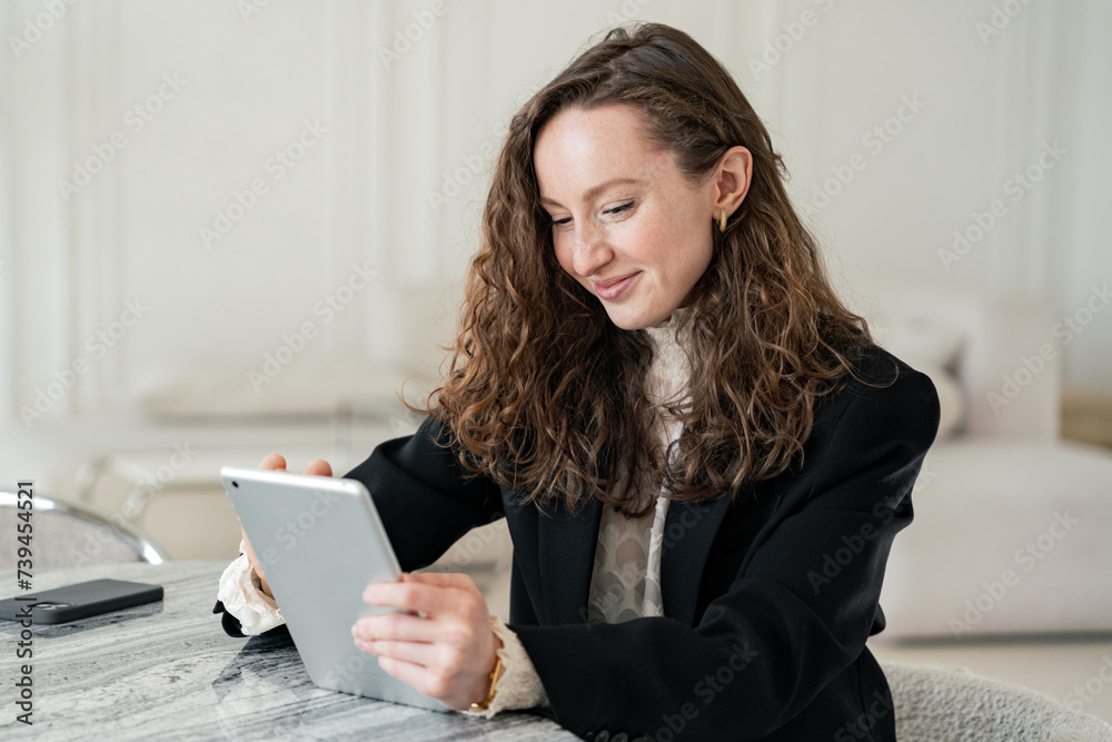 Professional woman using tablet in a bright, elegant interior, blending technology and comfort. Professional woman using tablet in a bright, elegant interior, blending technology and comfort.