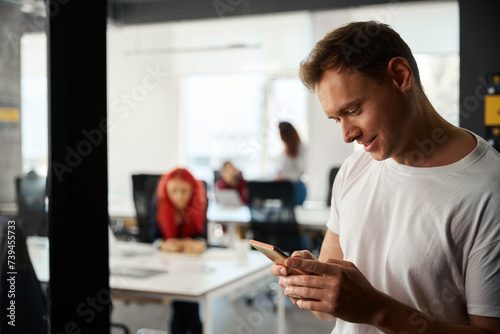 Close-up handsome young man playing games on smartphone instead of work