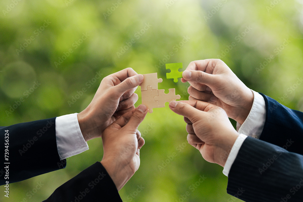 Office workers holding a jigsaw puzzle, teamwork and unity. Charity, volunteering, problem solving, business unity, business teamwork, success and strategy. Green background. Office workers holding a jigsaw puzzle, teamwork and unity. Charity, volunteering, problem solving, business unity, business teamwork, success and strategy. Green background.