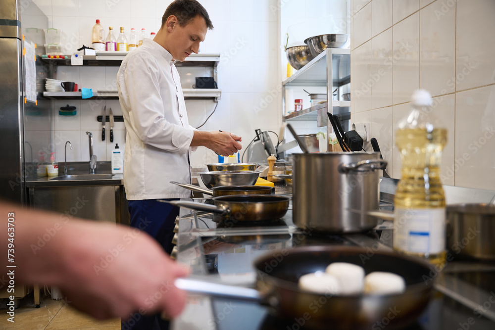 Young chef is preparing food in a restaurant kitchen Young chef is preparing food in a restaurant kitchen