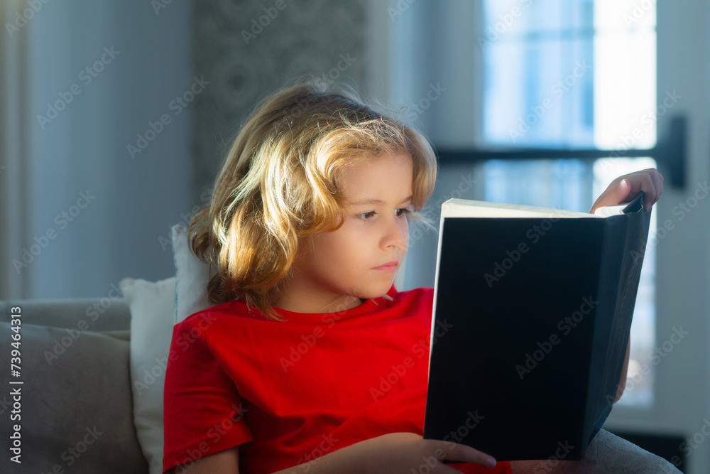 Reading book child concept. Kids and literature. Child reading book, sitting at home in cozy living room on couch. Reading book child concept. Kids and literature. Child reading book, sitting at home in cozy living room on couch.