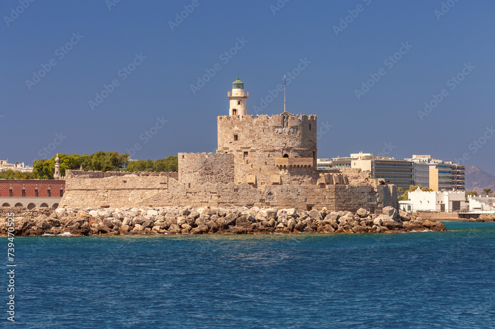 Old stone lighthouse at Fort St. Nicholas in Rhodes on a sunny day.