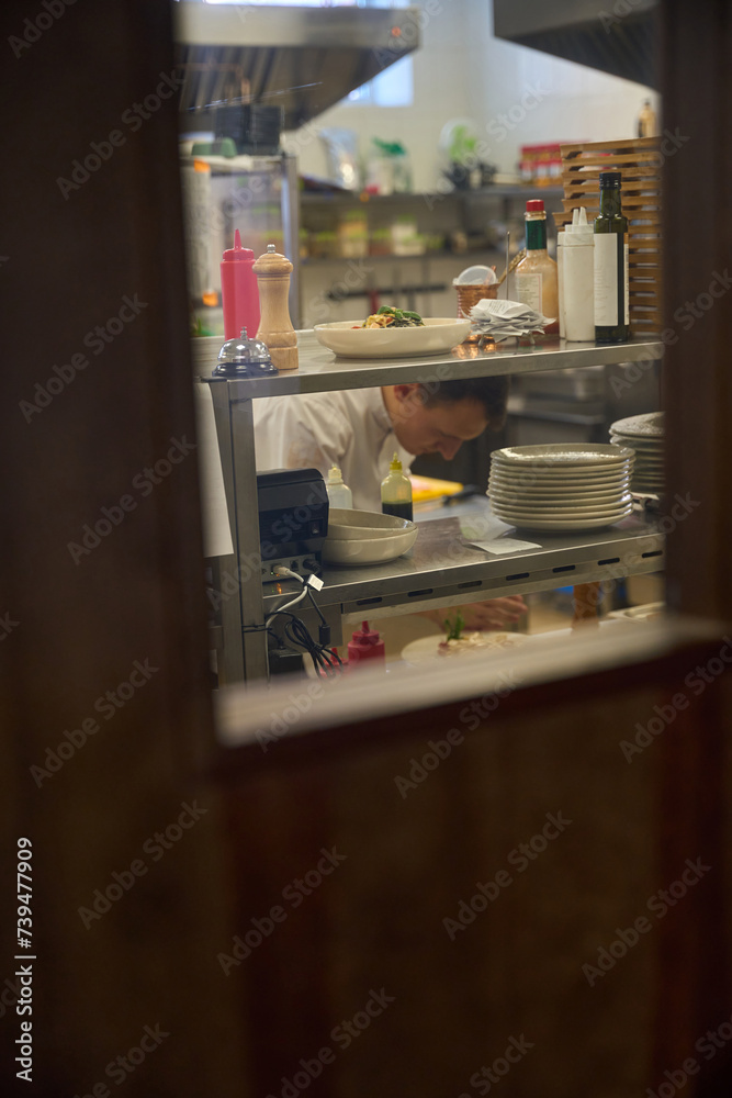 Man is at his workplace in a restaurant kitchen