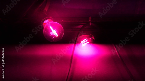 Ampoule d'éclairage de couleur violet ou orange, terrasse extérieure de nuit parisien, éclairage moderne, consommation d'énergie ou d'électricité, néons, reflet de lumière, projection d'éclairage, photo