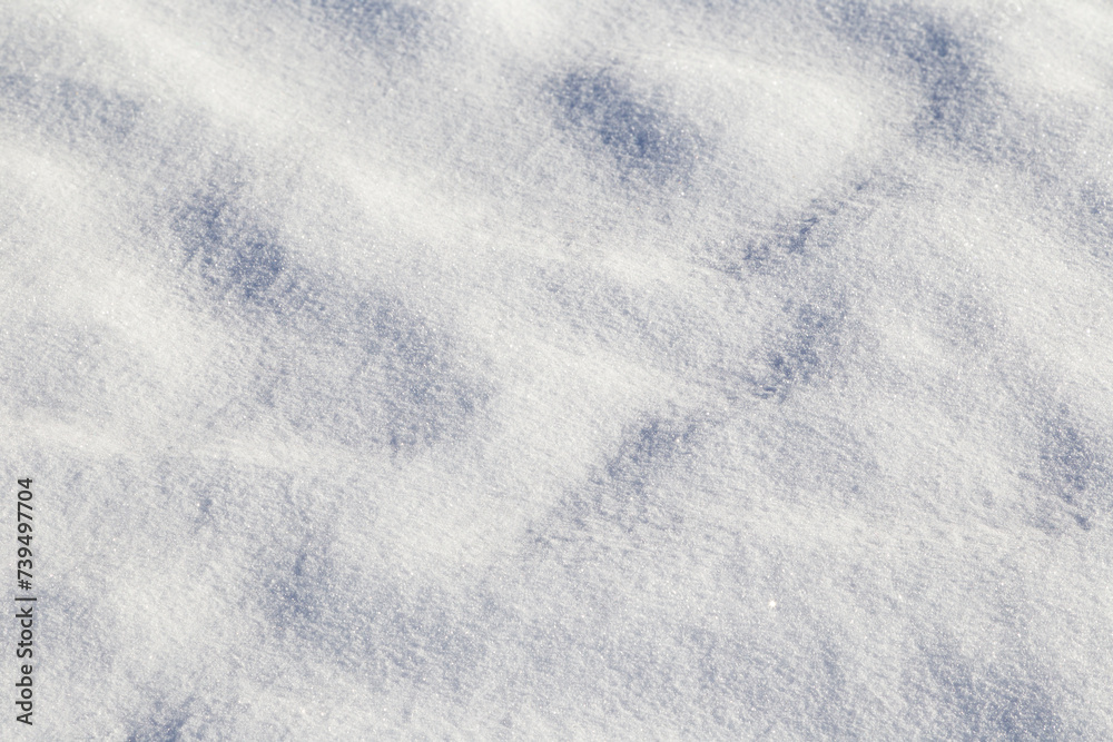Close-up of fresh snow on the ground in the winter on a sunny day, viewed from above. Abstract full frame textured background with copy space. Top view.