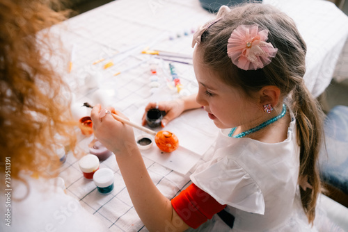 Little girl painting the egg , preparing for Easter at home