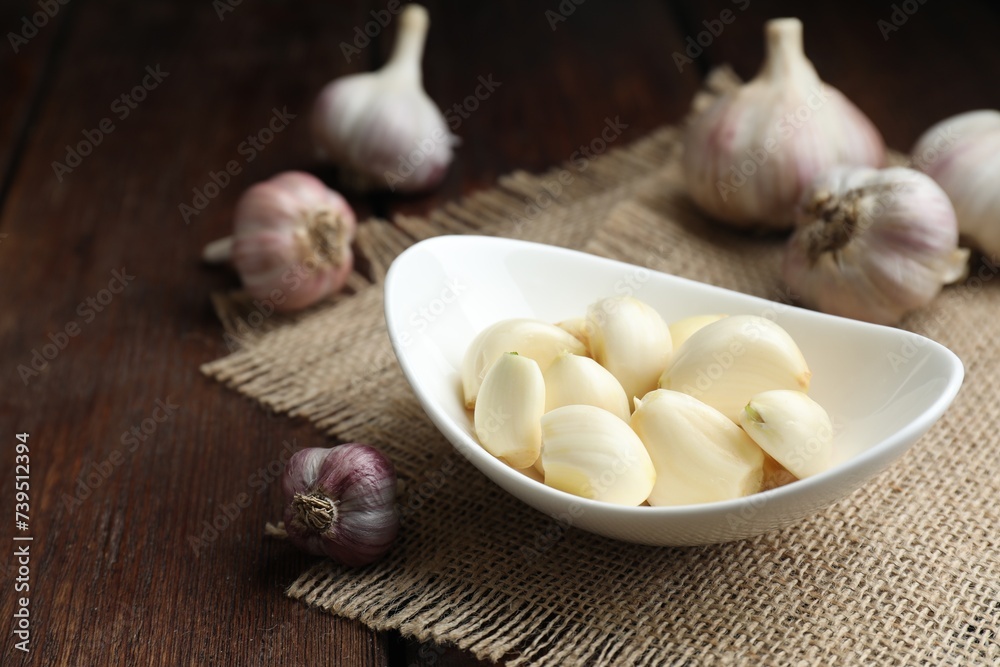 Fresh garlic cloves and bulbs on wooden table. Space for text Fresh garlic cloves and bulbs on wooden table. Space for text