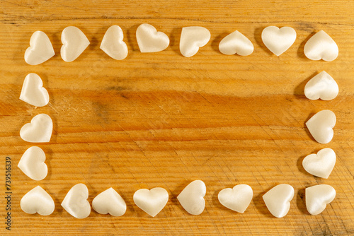 Rectangle frame of soft little white hearts on shaved wood