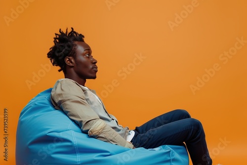 Handsome african american man sitting on comfortable beanbag chair © Alina