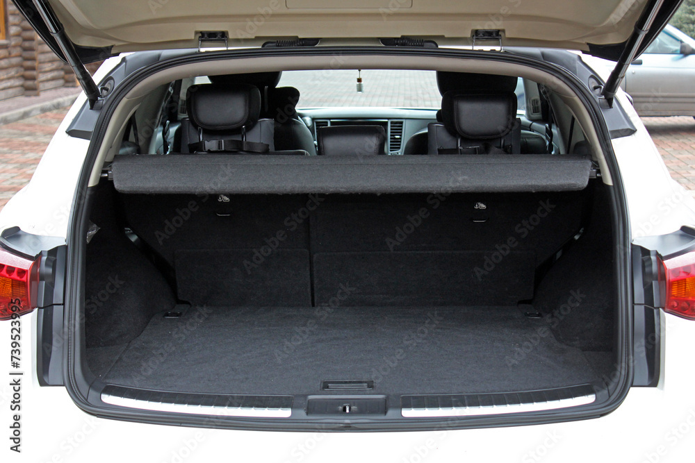 White lux SUV open trunk. Open empty trunk in the modern SUV. Car boot space shot. Modern SUV open trunk. Ready for luggage loading. Front view.