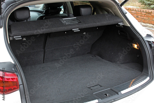 White lux SUV open trunk. Open empty trunk in the modern SUV. Car boot space shot. Modern SUV open trunk. Ready for luggage loading. Right view.