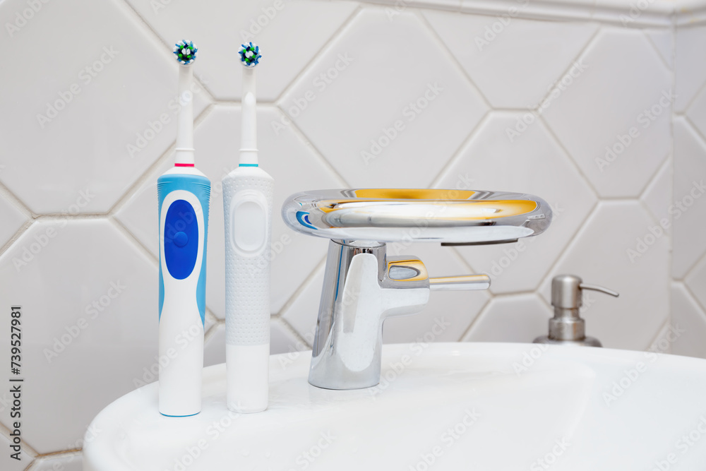 Modern Electric Toothbrushes by Bathroom Sink - obrazy, fototapety, plakaty 