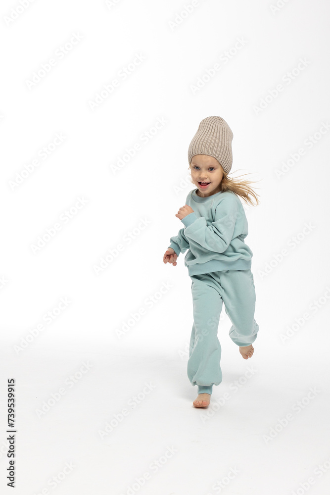 Portrait of beautiful cute little toddler girl. Child with funny face in mint sweatshirt and hat. Pretty smile kid in studio on white background. Portrait of beautiful cute little toddler girl. Child with funny face in mint sweatshirt and hat. Pretty smile kid in studio on white background.