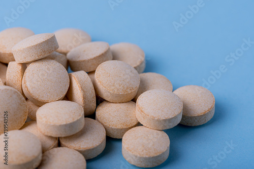 Orange pills vitamin C. pills on blue background.