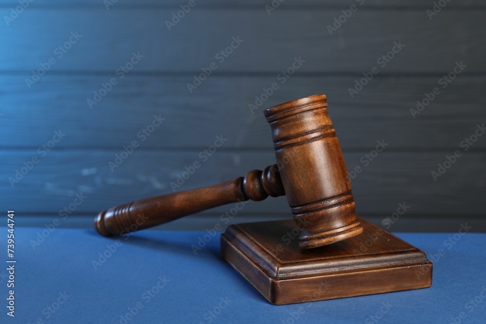Wooden gavel and sound block on blue table, closeup Wooden gavel and sound block on blue table, closeup