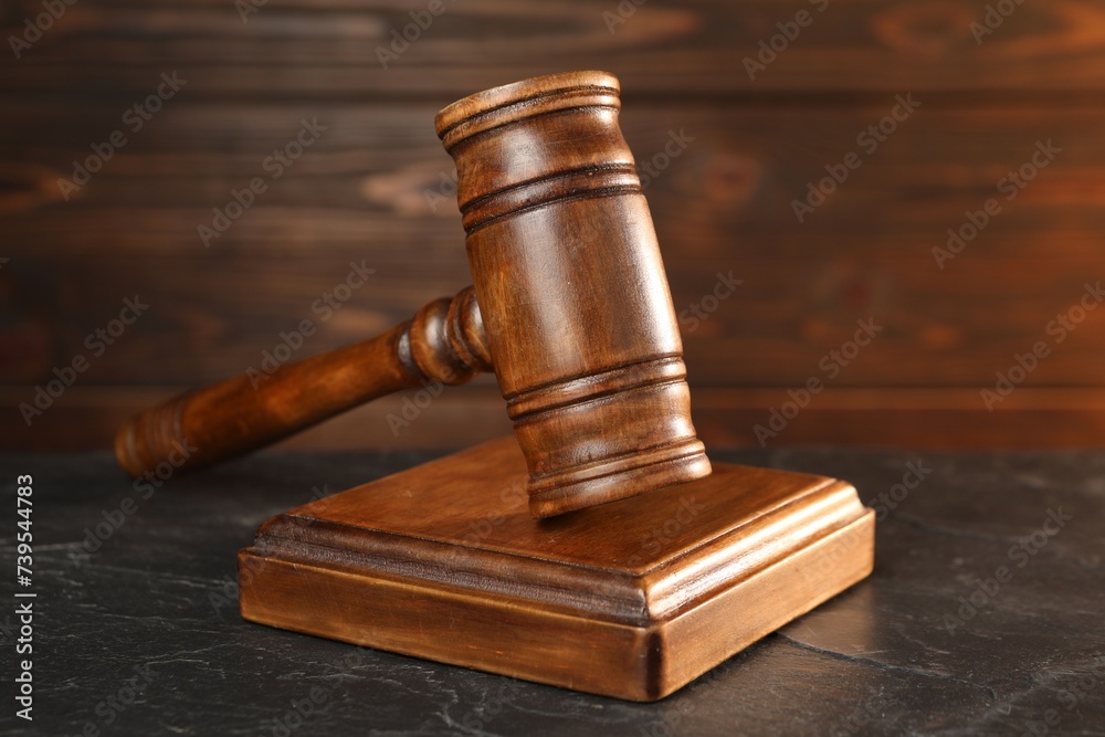 Wooden gavel and sound block on dark textured table, closeup Wooden gavel and sound block on dark textured table, closeup