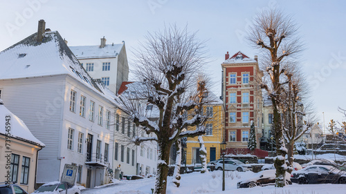 Typical houses in Bergen at winter, cold winter day on the streets of Bergen, snow covered roads and tall colorful houses.